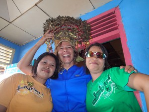 Monika tries on a traditional Indonesian head dress with some local ladies